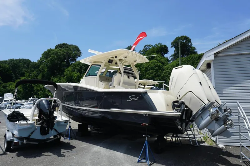 Slide: The Image of 2024 Scout 357LXF boat displayed outdoors with dual engines. - 1