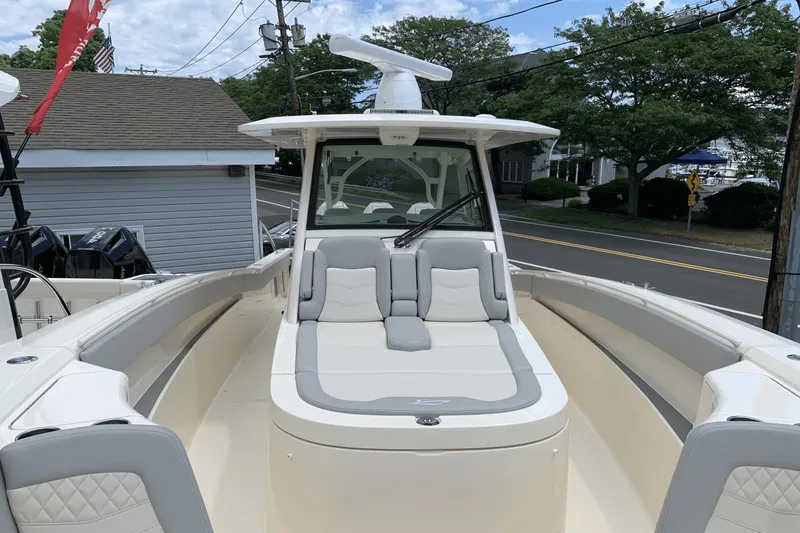 Slide: The Image of 2024 Scout 357LXF boat with spacious seating and modern design, docked near a road. - 15
