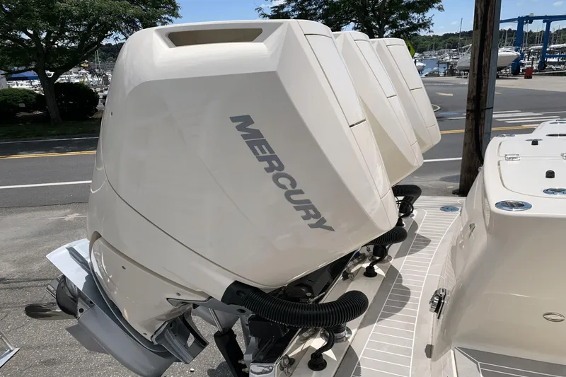Slide: The Image of 2024 Scout 357LXF boat with Mercury outboard engines, docked near a marina. - 4
