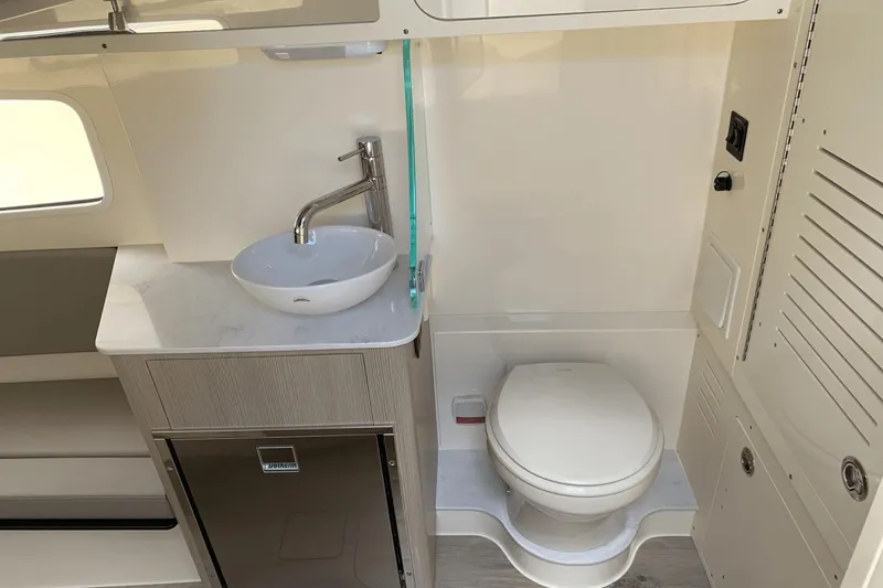 Slide: The Image of 2024 Scout 357LXF boat bathroom with modern sink, toilet, and storage cabinet. - 24