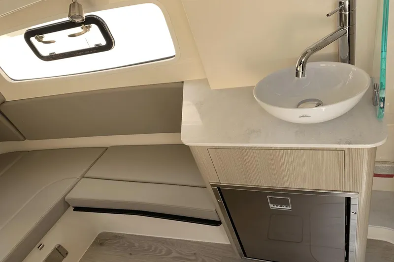 Slide: The Image of 2024 Scout 357LXF boat interior with sink, seating, and window. - 27