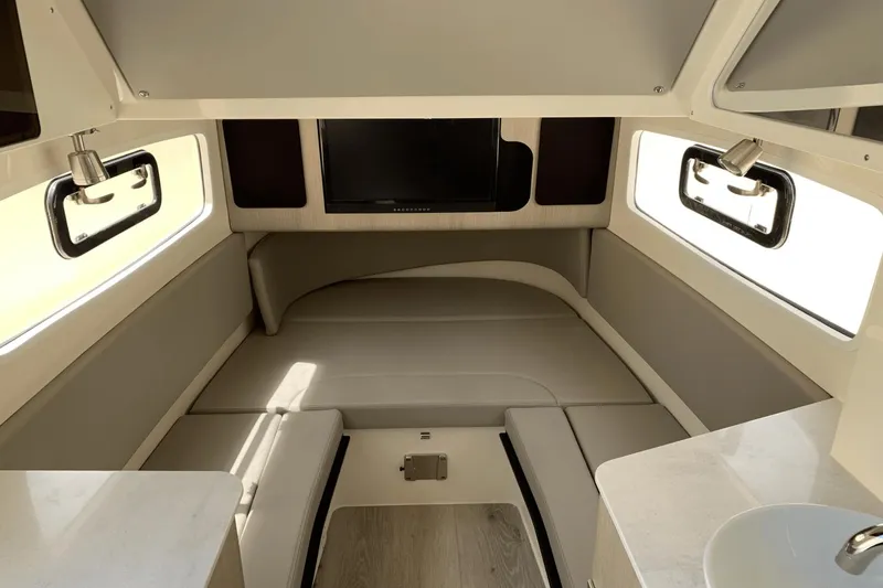 Slide: The Image of 2024 Scout 357LXF cabin interior with seating, windows, and TV. - 25
