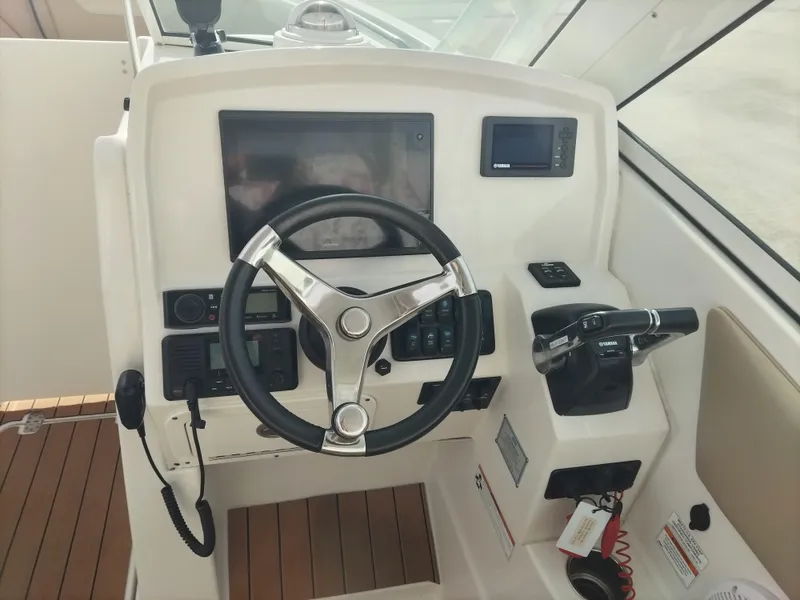 Slide: The Image of 2020 Sailfish 275 DC boat helm with steering wheel and control panel. - 11