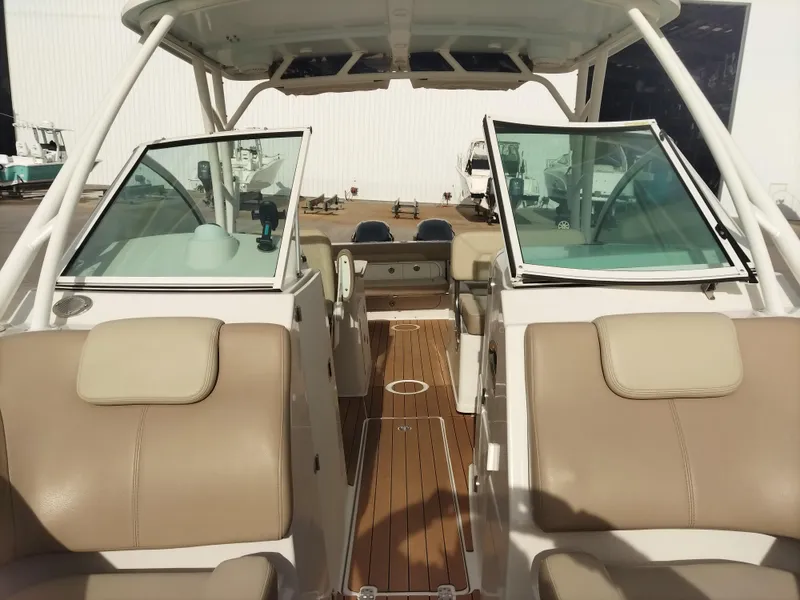 Slide: The Image of 2020 Sailfish 275 DC boat interior with beige seating and wooden flooring. - 15