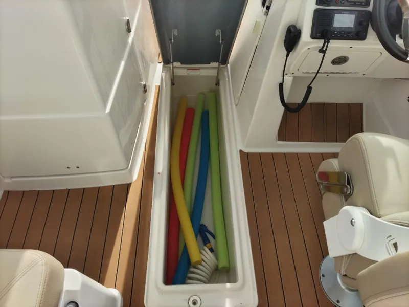 Slide: The Image of 2020 Sailfish 275 DC boat interior with colorful pool noodles in storage compartment. - 16