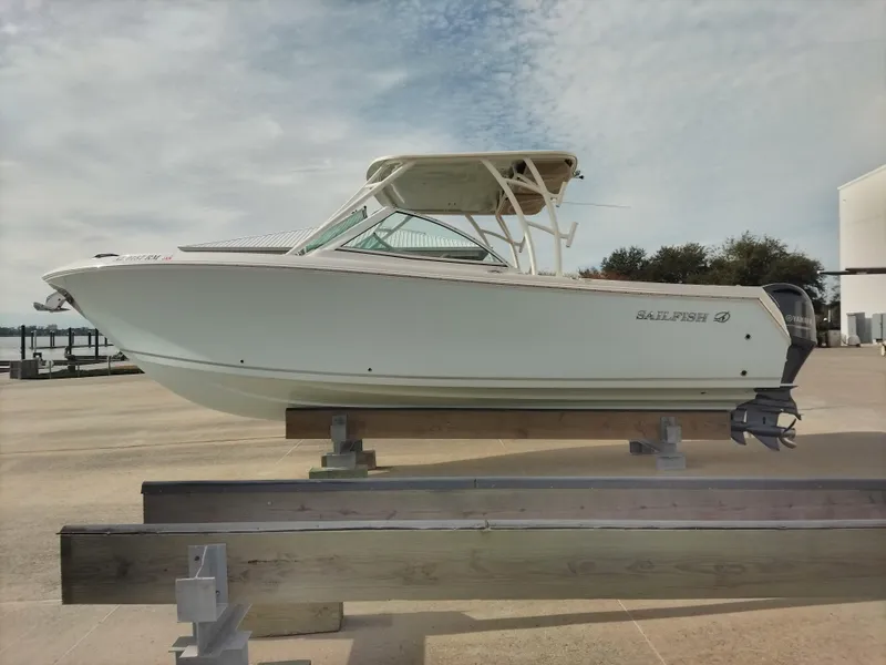 Slide: The Image of 2020 Sailfish 275 DC boat on display, side view, clear sky background. - 4