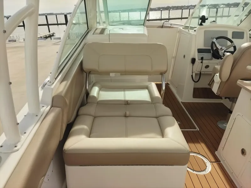 Slide: The Image of 2020 Sailfish 275 DC boat interior with beige seating and wooden flooring. - 8