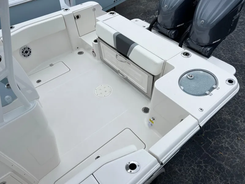 Slide: The Image of 2024 Robalo R270 boat deck with seating, storage, and dual engines. - 12