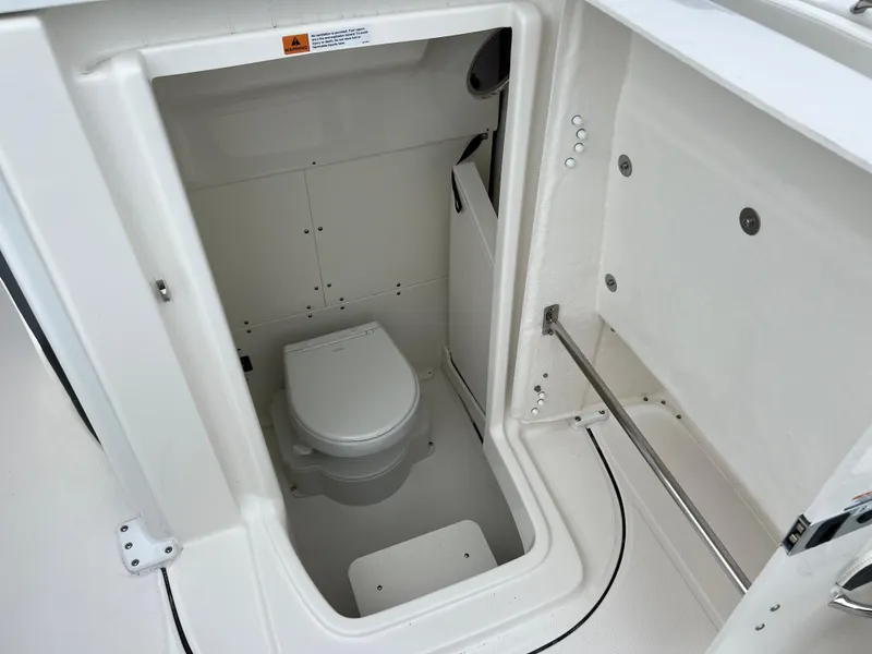 Slide: The Image of 2024 Robalo R270 boat interior with compact marine toilet. - 14