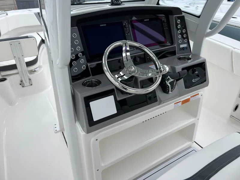 Slide: The Image of 2024 Robalo R270 boat dashboard with dual screens and steering wheel. - 7