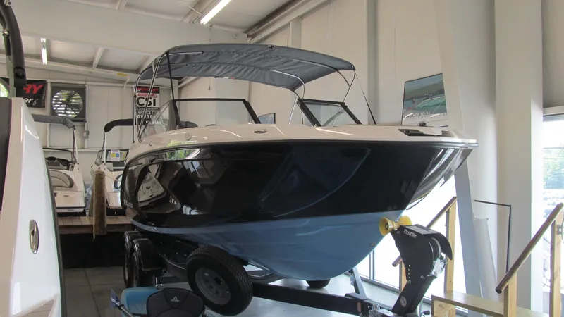 Slide: The Image of 2024 Yamaha Boats SX220 displayed indoors on a trailer. - 4
