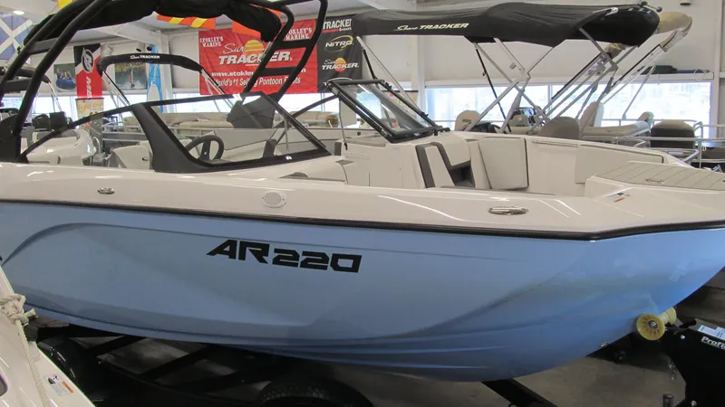 Slide: The Image of 2024 Yamaha Boats AR220 in showroom, sleek design, white and blue exterior. - 3