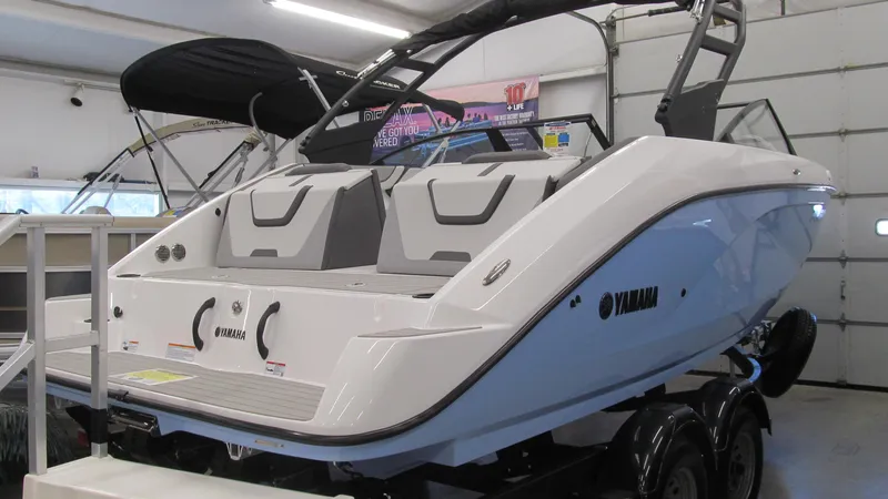 Slide: The Image of 2024 Yamaha Boats AR220 in showroom, featuring sleek design and modern seating. - 4
