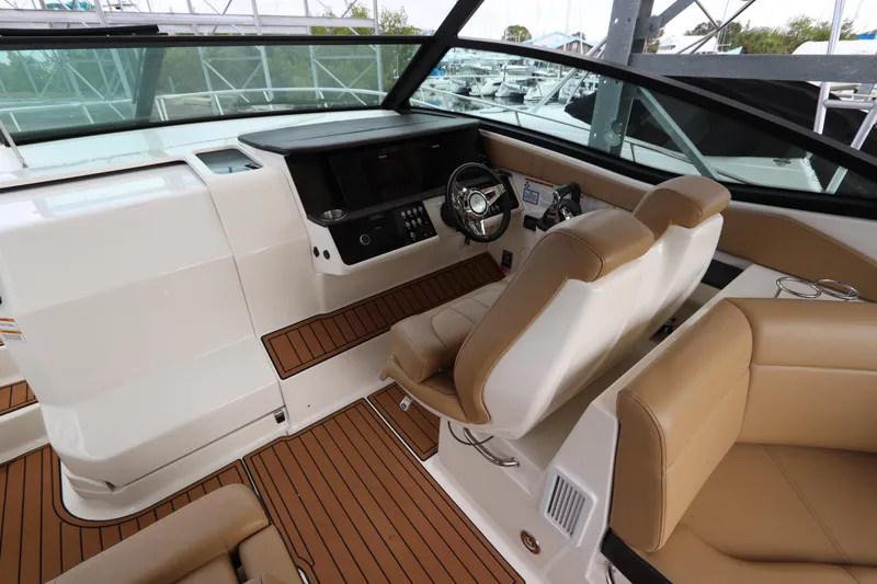 Slide: The Image of 2019 Sea Ray Sundancer 320 cockpit with modern helm, tan seating, and wood accents. - 16