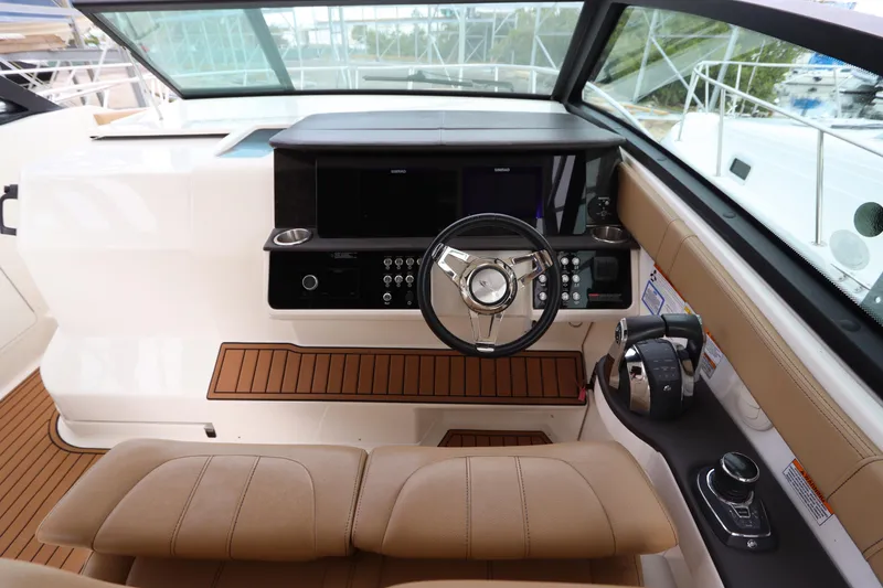 Slide: The Image of 2019 Sea Ray Sundancer 320 helm with modern controls and tan seating. - 17