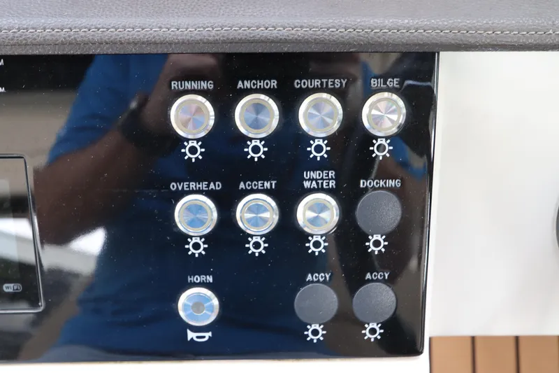Slide: The Image of Control panel of a 2019 Sea Ray Sundancer 320 boat with various switches. - 22