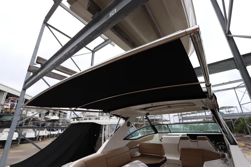 Slide: The Image of 2019 Sea Ray Sundancer 320 with extended sunshade in marina. - 30