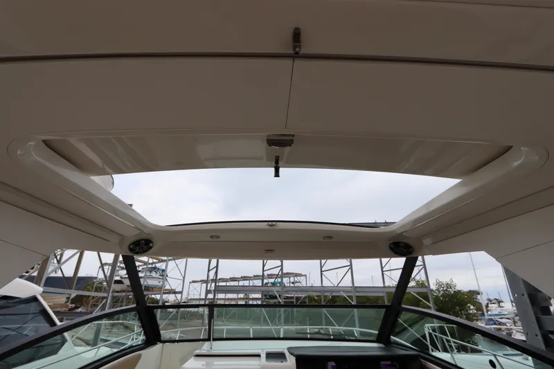 Slide: The Image of 2019 Sea Ray Sundancer 320 boat interior with open sunroof, docked at marina. - 33