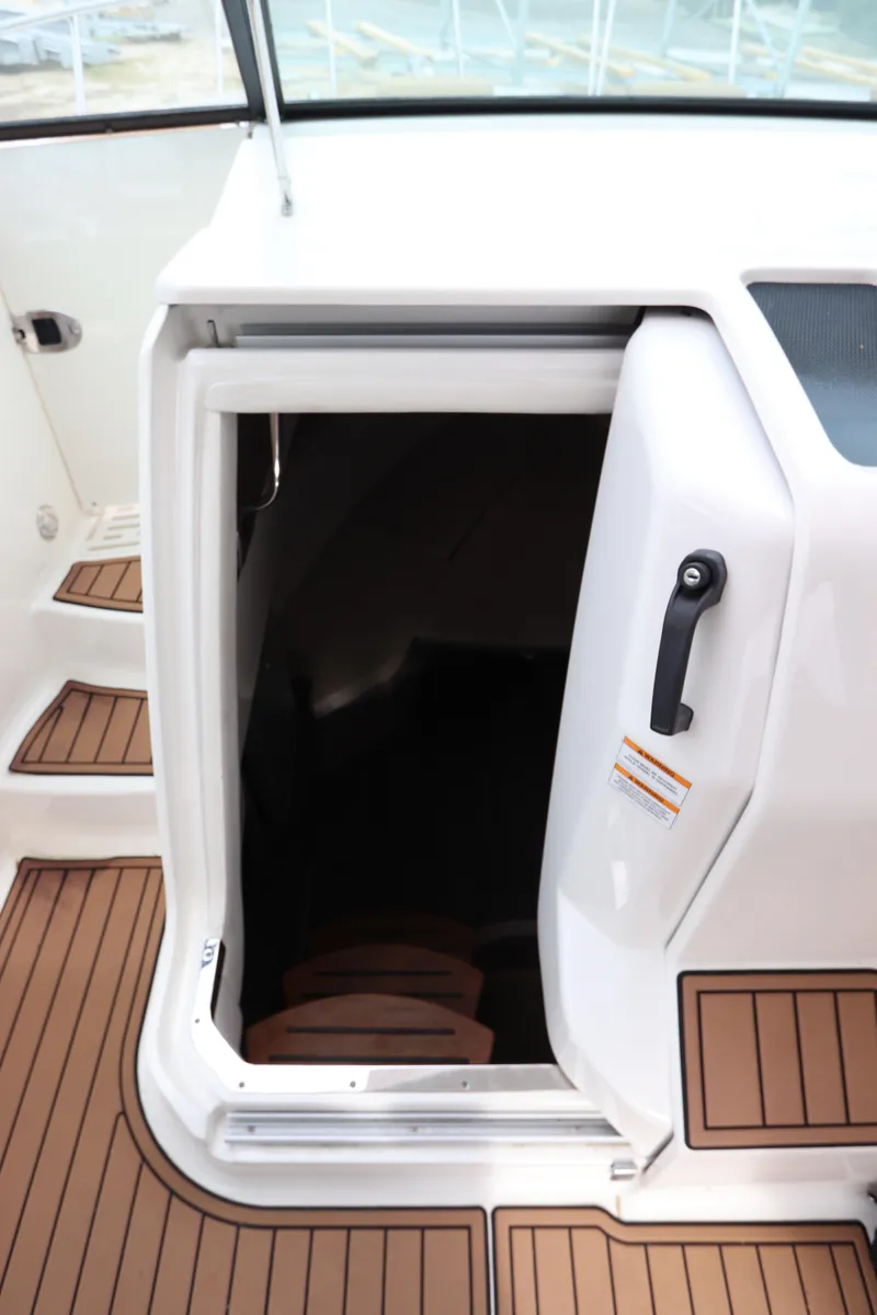 Slide: The Image of 2019 Sea Ray Sundancer 320 cabin entrance with teak flooring and white door. - 34