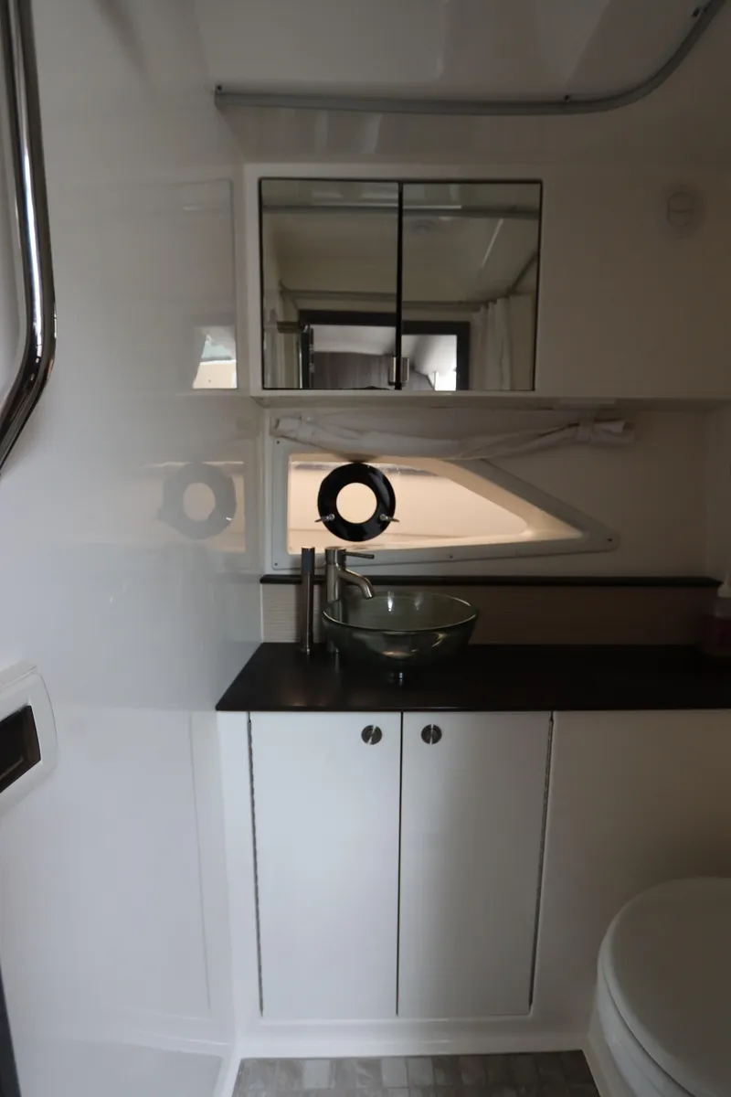Slide: The Image of 2019 Sea Ray Sundancer 320 bathroom with modern sink, mirror, and storage cabinets. - 40