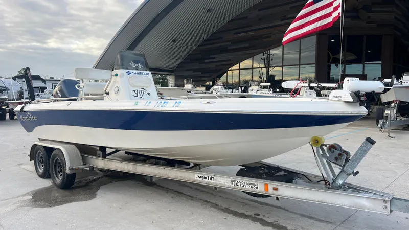 Slide: The Image of 2005 NauticStar 2200 boat on a trailer with an American flag in the background. - 3