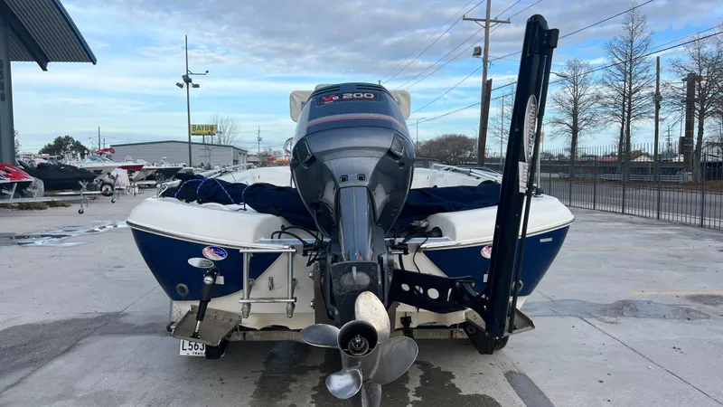 Slide: The Image of 2005 NauticStar 2200 boat with outboard motor, docked at a marina. - 5
