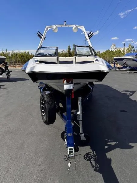 Slide: The Image of 2024 Axis A20 boat on trailer, parked outdoors under clear blue sky. - 4