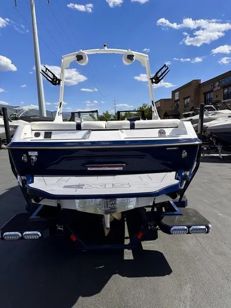 Slide: The Image of 2024 Axis A20 boat, rear view, parked outdoors under a clear blue sky. - 8
