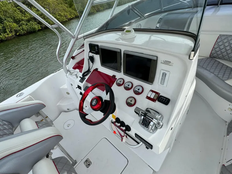 Slide: The Image of 2008 Donzi 38 ZSF boat cockpit with steering wheel, gauges, and navigation screens. - 16
