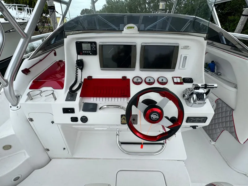 Slide: The Image of 2008 Donzi 38 ZSF boat cockpit with steering wheel, gauges, and navigation screens. - 23
