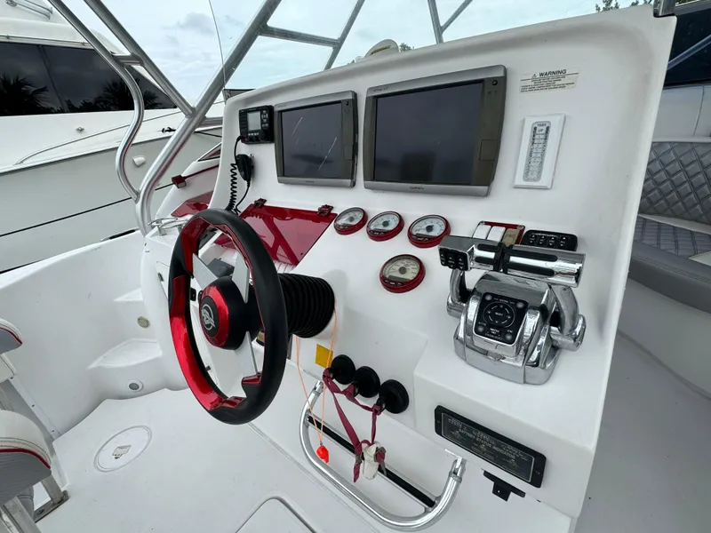 Slide: The Image of Control panel of a 2008 Donzi 38 ZSF boat with steering wheel and navigation instruments. - 24