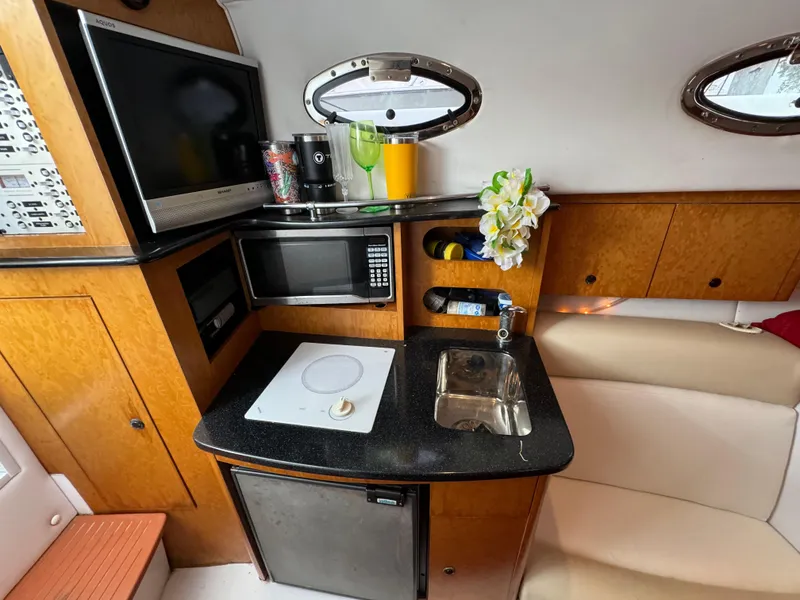 Slide: The Image of 2008 Donzi 38 ZSF cabin kitchen with microwave, sink, and TV. - 31