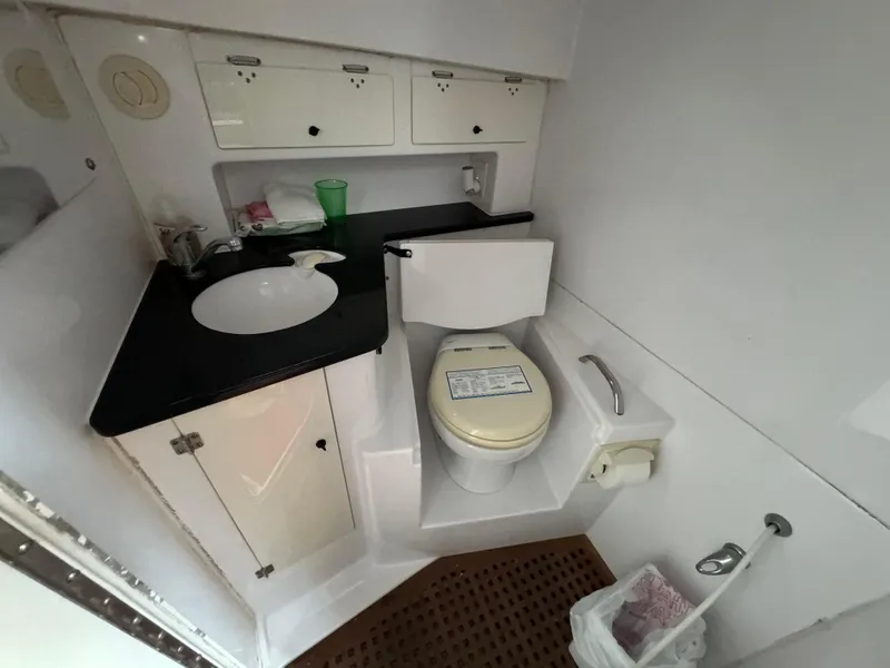 Slide: The Image of 2008 Donzi 38 ZSF boat bathroom with sink, toilet, and storage cabinets. - 34