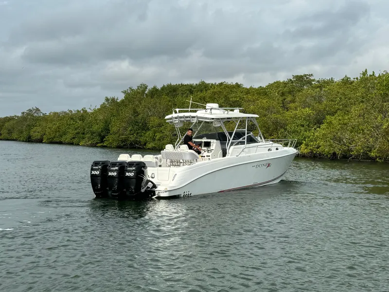 Slide: The Image of 2008 Donzi 38 ZSF boat cruising on a calm river with lush greenery. - 4