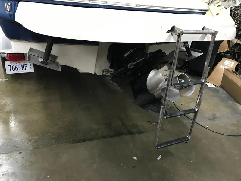 Slide: The Image of 2004 Sea Ray 240 Sundeck stern with propeller and swim ladder in garage. - 14