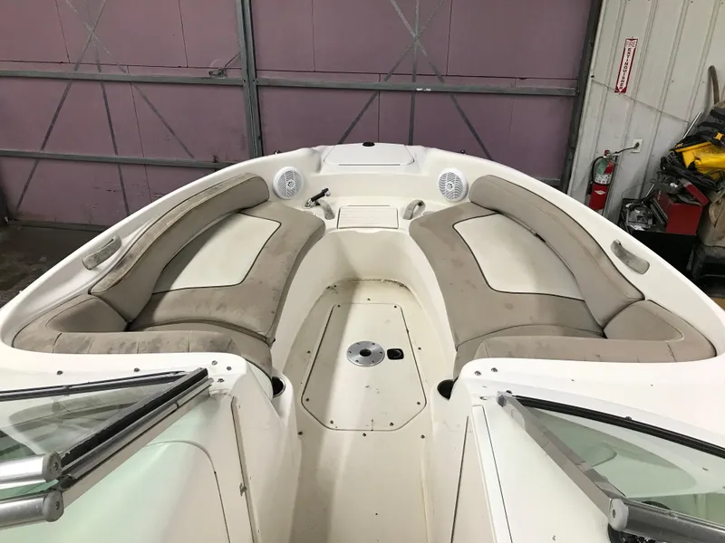 Slide: The Image of 2004 Sea Ray 240 Sundeck boat interior with beige seating and speakers. - 15