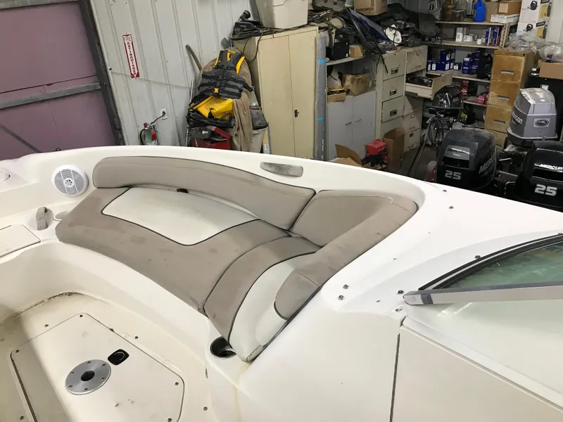 Slide: The Image of 2004 Sea Ray 240 Sundeck boat interior with beige seating in a storage area. - 16