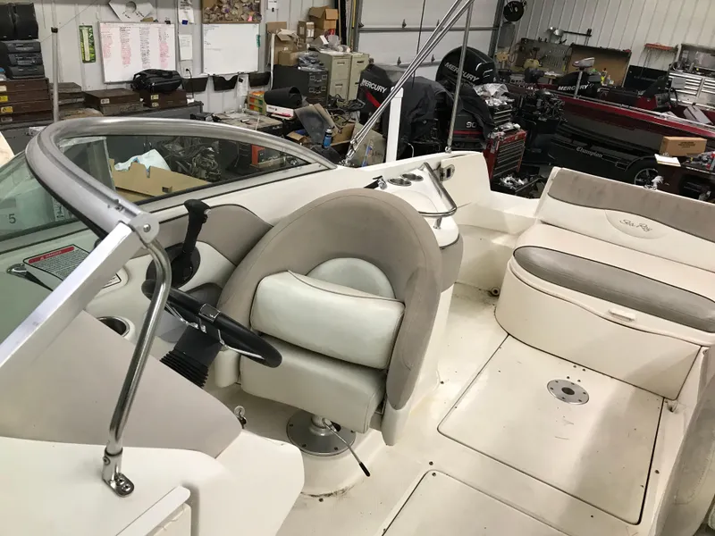 Slide: The Image of 2004 Sea Ray 240 Sundeck interior with helm and seating area in a workshop. - 18