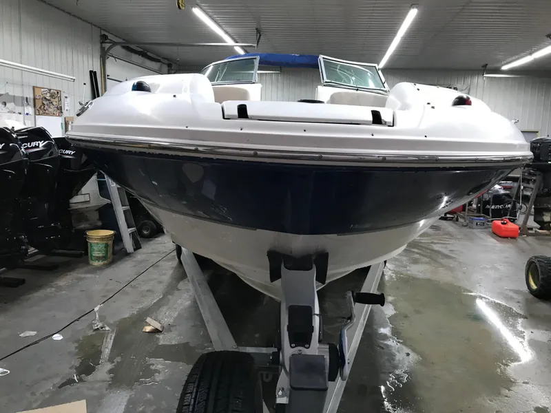 Slide: The Image of 2004 Sea Ray 240 Sundeck boat in a garage, front view on a trailer. - 4