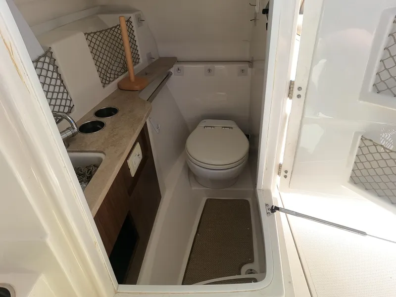 Slide: The Image of 2017 Sailfish 245 DC boat interior bathroom with sink and toilet. - 10
