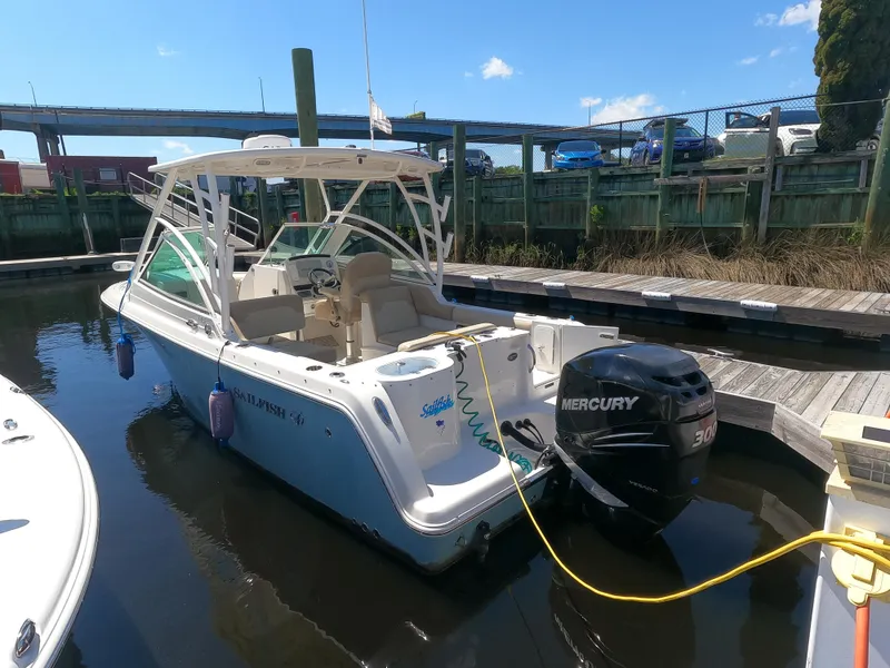 Slide: The Image of 2017 Sailfish 245 DC boat docked, featuring a Mercury 300 outboard motor. - 2