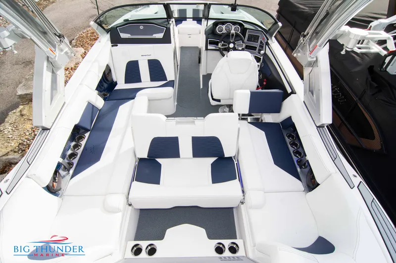 Slide: The Image of 2024 MasterCraft X22 boat interior with white and blue seating, Big Thunder Marine logo. - 15