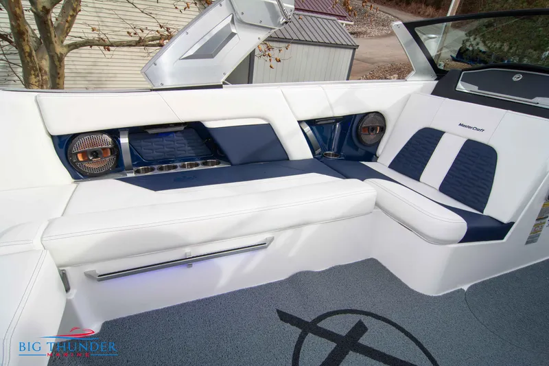 Slide: The Image of 2024 MasterCraft X22 boat interior with white and blue seating, premium audio system. - 19