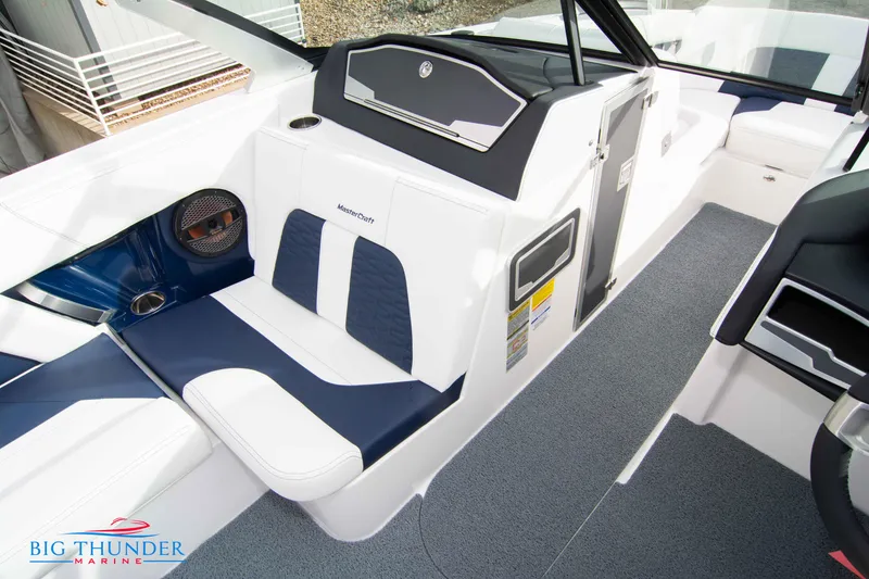 Slide: The Image of 2024 MasterCraft X22 boat interior with white and blue seating, Big Thunder Marine logo. - 37