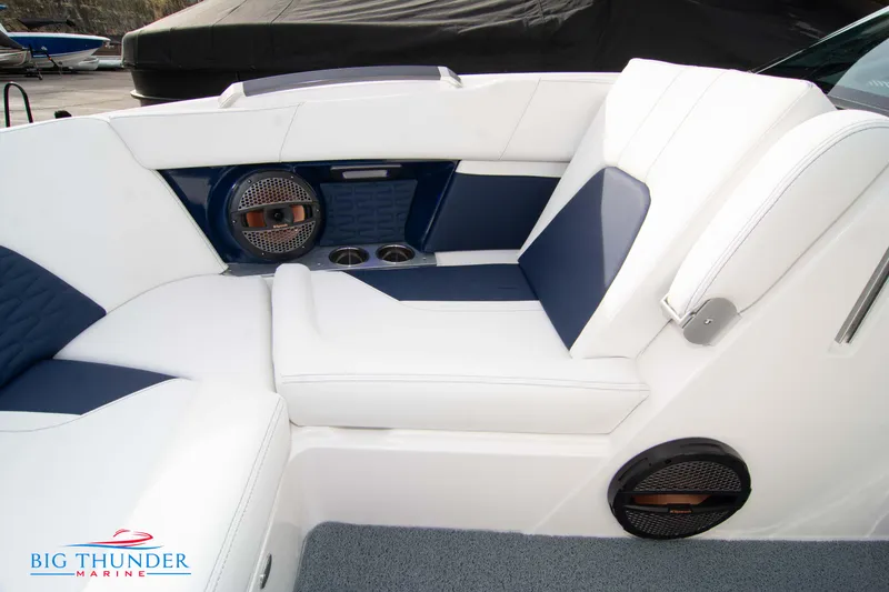 Slide: The Image of 2024 MasterCraft X22 boat interior with white and blue seating, speakers, and cup holders. - 41