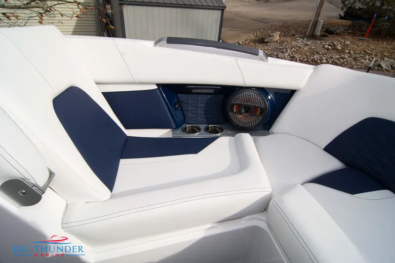 Slide: The Image of 2024 MasterCraft X22 boat interior with white and navy seating, cup holders, and speaker. - 42