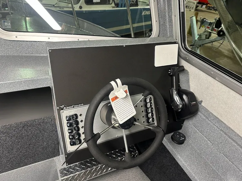 Slide: The Image of 2024 KingFisher 2325 Coastal Express boat helm with steering wheel and control panel. - 14