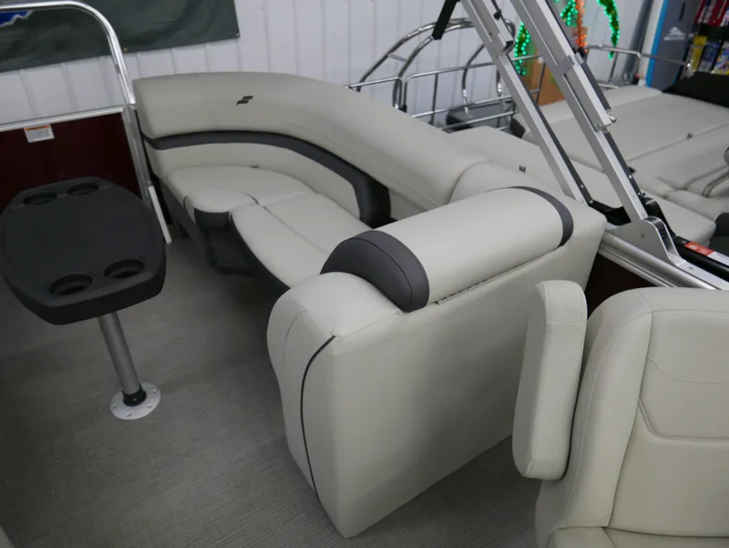Slide: The Image of 2024 Starcraft EX 22 R boat interior with beige seating and cup holder table. - 17