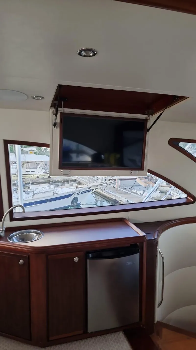 Slide: The Image of Interior of 2009 Bertram 700 Enclosed yacht with TV, sink, and mini-fridge. - 15