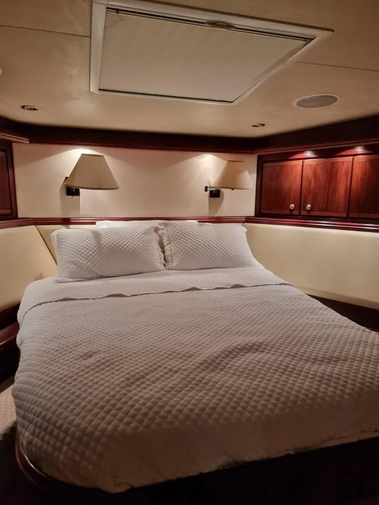 Slide: The Image of Luxurious bedroom in a 2009 Bertram 700 Enclosed yacht with cozy lighting. - 18